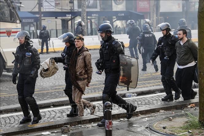 Cảnh sát chống bạo động bắt giữ những người biểu tình "Áo vàng" quá khích tại Paris ngày 16/3. Ảnh: AFP/TTXVN