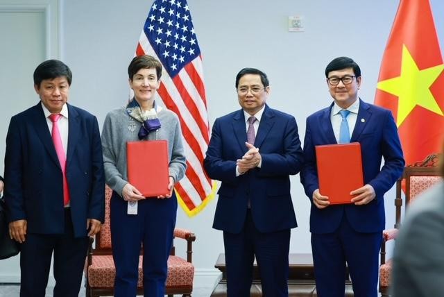 Bà Stephanie von Friedeburg – Phó Chủ tịch Điều hành Cao cấp IFC (thứ hai từ trái sang) và ông Trần Hoài Nam - Phó Tổng giám đốc HDBank (ngoài cùng bên phải) trao văn kiện ký kết dưới sự chứng kiến của Thủ tướng Chính phủ Phạm Minh Chính (thứ hai từ phải sang).